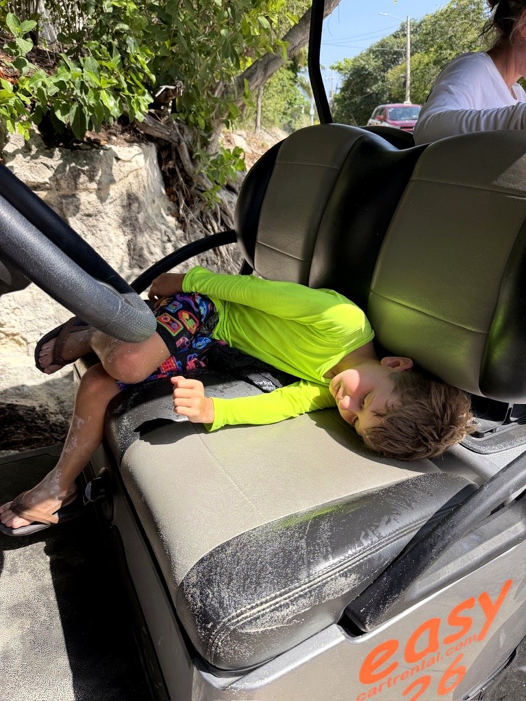 A child napping after a golf cart day