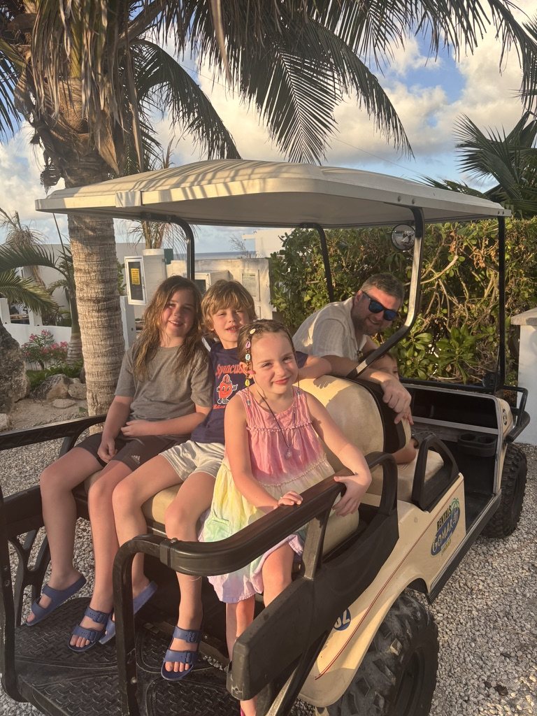 Family riding together in a golf cart